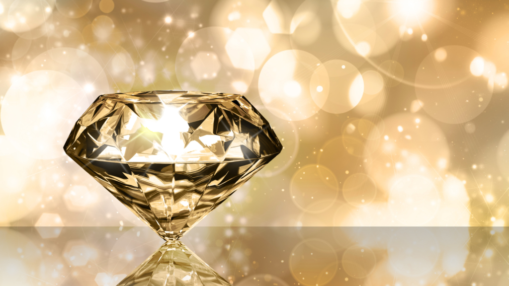 A luxurious golden diamond displayed on a reflective surface, glowing against a sparkling gold-toned background.